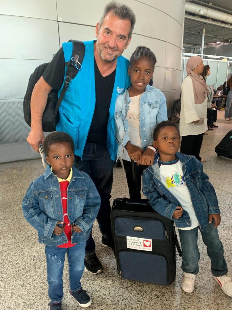 Philippe, a caring travelling companion, enjoys a moment of complicity with the children he has escorted through the air.